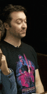 a man wearing a black t-shirt that says technicolor on it