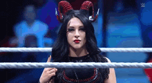 a woman in a devil costume is in a wrestling ring .