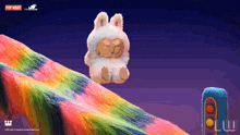 a stuffed animal sitting on top of a rainbow colored hill with pop mart written on the bottom right