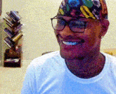 a man wearing glasses and a multicolored hat is smiling