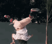 a person is doing a handstand in front of a fence
