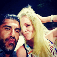 a man with a beard and a woman with blonde hair are posing for a photo