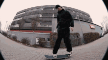 a man is riding a skateboard in front of a building that has the word kiwi on it