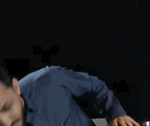 a man with a beard wearing a blue shirt and tie is making a funny face .