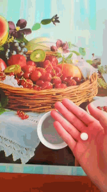 a person holding a small white pill in front of a picture of fruit
