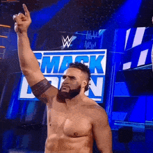 a shirtless wrestler stands in front of a sign that says smackdown