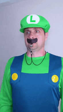 a man in a luigi costume has a whistle around his mouth