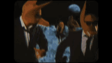 a man in a suit and tie has a fox mask on his face