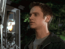 a man in a black jacket is looking at something