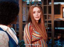 a woman with long red hair is talking to another woman who says her name was pietro