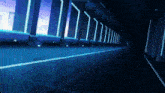 a very long hallway with blue lights on the walls and floor