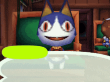 a blue and white cat with big orange eyes is sitting at a table