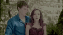 a man and a woman are standing next to each other .