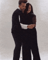 a man and a woman are hugging each other