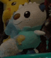 a stuffed animal is sitting on a shelf next to a yellow stuffed animal .