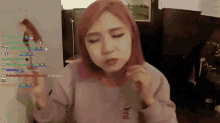 a girl with pink hair is playing a video game on a computer screen