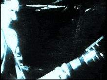 a man playing a guitar in a dark room