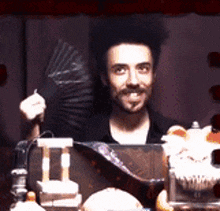 a man with a beard is holding a fan in front of him