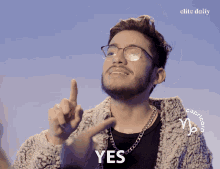 a man wearing glasses and a sweater with the word yes on it