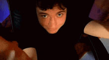 a close up of a person 's face in a black shirt