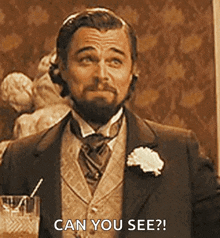 a man in a suit and tie is holding a glass with a straw and asking if he can see .