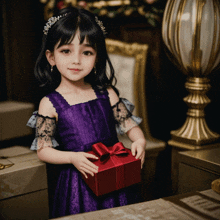a little girl in a purple dress holding a red gift box