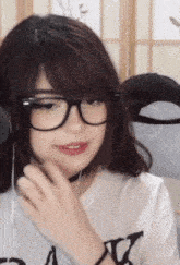 a girl wearing glasses and a t-shirt that says " a " on it