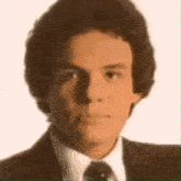 a close up of a man 's face with a suit and tie