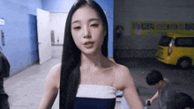 a woman stands in front of a yellow van with a sign that says ' korean ' on it