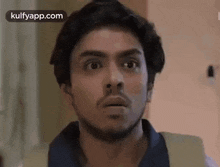 a man with a beard is making a surprised face and looking at the camera .