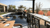 a table and chairs in front of a pool