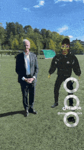 a man in a suit is standing next to a man in a mask on a field with a tiktok logo in the corner