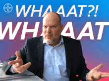 a man in a suit is standing in front of a sign that says " whaaat "