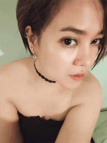 a woman wearing a choker necklace and earrings