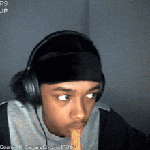 a man wearing headphones and a headband eating noodles
