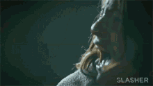 a close up of a woman 's face in a dark room with the word slasher written on the bottom .
