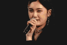 a woman is smiling while holding a microphone in her hand .