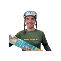 a man wearing a helmet and an endura shirt smiles