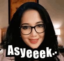a woman wearing glasses is smiling with the words asyeeek above her head