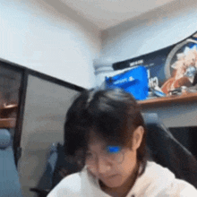 a man wearing glasses is sitting in a chair in front of a computer .