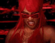 a woman with red hair and sunglasses is making a face .