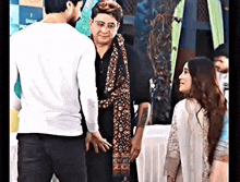 a man and a woman are standing next to each other talking to each other .