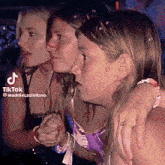 a group of women are standing next to each other and one of them has a ring on her finger .