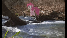 a pink pony is standing next to a river