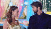 a man and a woman are standing next to each other and looking at each other in a room .