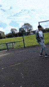 a man is standing on a basketball court in a park