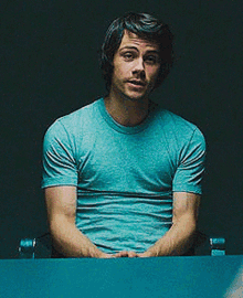a man in a blue shirt is sitting at a desk