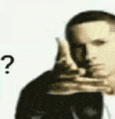 a man in a suit is pointing at something with a question mark .