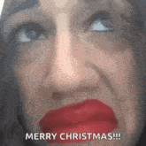 a woman with red lipstick on her lips is making a funny face and says merry christmas .