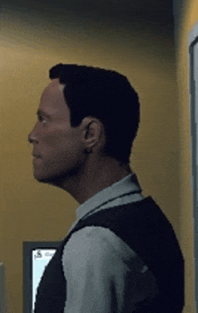 a man in a suit is standing in front of a yellow wall and looking at something .